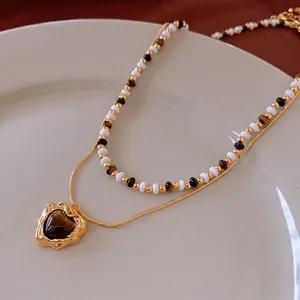 Vintage gold plated double-layer necklace with heart tiger eye pendant on a display tray