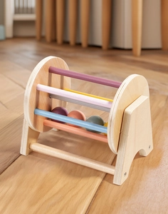 Close-up of a colorful Montessori wooden spinning drum for baby coordination training