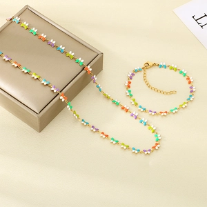 Conjunto detallado de collar y pulsera de mariposa dorada sobre fondo beige con caja de regalo