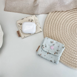 Macro view of floral fabric organizer pouch holding a wireless earphone case