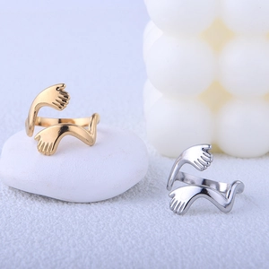 Detailed close-up of gold and silver hugging hands open rings with polished finish