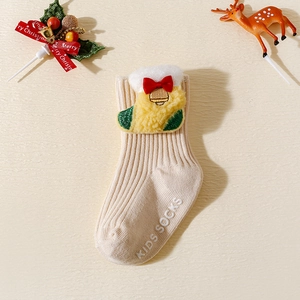 Détail de chaussettes de Noël beiges pour bébé avec patch 3D et semelles antidérapantes