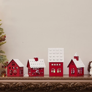 Set of four red iron Christmas house candle holders with snowy roofs on a mantelpiece