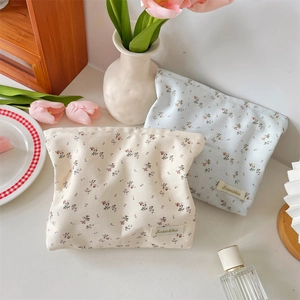 Detailed view of floral pattern and woven label on a large cotton cosmetic storage bag