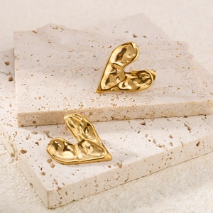 Textured 18K gold plated heart stud earrings with a molten rock finish on beige stone