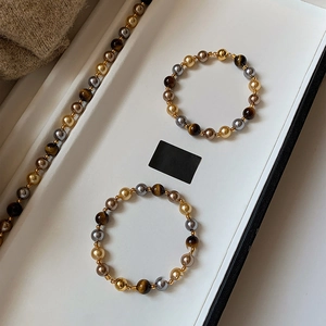 Détail d'un ensemble de bracelets perlés vintage français en oeil de tigre sur un plateau