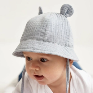 Close-up of soft cotton baby sun hat with cute ears and secure chin straps in light grey blue