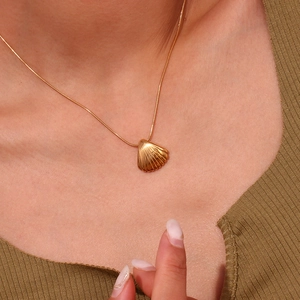 Primo piano di una collana con ciondolo a conchiglia placcata oro 18K su una modella