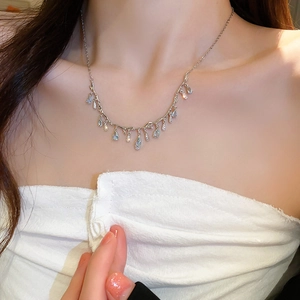 Detail of silver tassel necklace with light blue teardrop stones and shimmering crystals