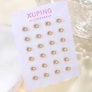 Macro detail of 20 pairs of gold-plated stud earrings with clear cubic zirconia on card