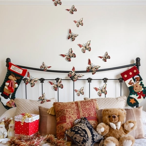 3D Christmas butterfly wall stickers with floral patterns on a cozy bedroom background