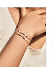 Dettaglio di sottili bracciali in argento S925 in oro e argento con zirconi scintillanti