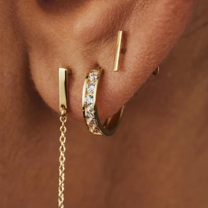 Macro shot of gold cross star hoop earrings and stud set with pavé cubic zirconia