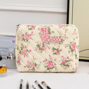 Close-up of quilted floral cotton makeup bag with pink flowers and metal zipper