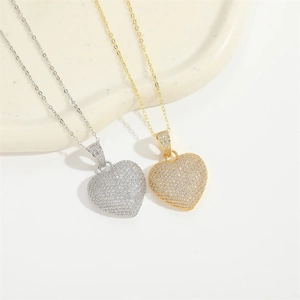 Close-up of heart pendants with sparkling pavé crystals in gold and silver finishes