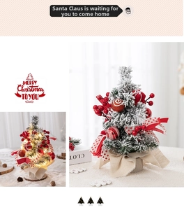 Miniature flocked pink Christmas tree with red berries, ribbons and warm LED lights