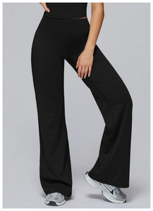 Detail of black high-waisted flared sports pants with elastic fabric on model