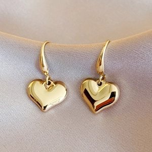 Elegant 14k gold-plated heart-shaped drop earrings on champagne satin background