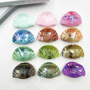 Flat lay of multiple shell-shaped acetate hair claws with marble and gradient textures