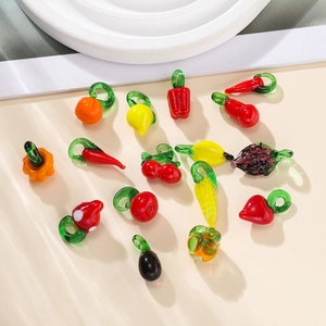 Detailed overhead shot of colorful handcrafted fruit and vegetable glass pendants for DIY