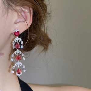 Detailed side view of silver tassel earrings with sparkling red heart and teardrop zircon