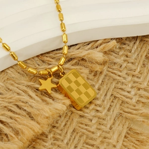 Collana a sfere in acciaio al titanio dorato con placca a scacchi e ciondolo a stella