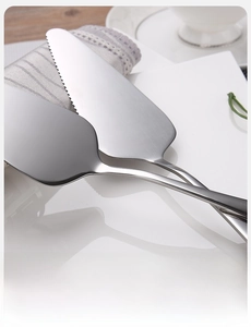 Close-up of stainless steel cake server with serrated edge and seamless handle