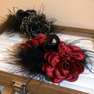 Elegant fabric rose flower hair claw clips with black feathers in burgundy and black tones