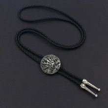 Detail of western bolo tie with silver scorpion medallion and black braided cord