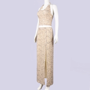 Dettaglio del completo a due pezzi in paillettes oro champagne con spacco laterale su manichino
