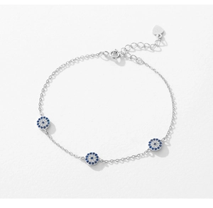 Detailed view of S925 sterling silver bracelet with blue cubic zirconia evil eye charms