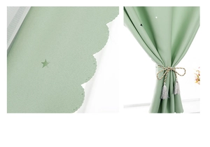 Detail of green blackout curtain with star cut-outs and woven tassel tieback holder