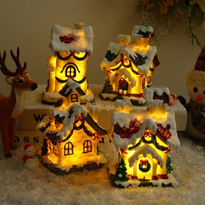 Set of 4 glowing resin Christmas village houses with warm LED lights and snowy details