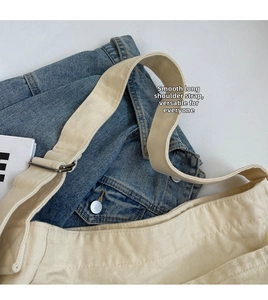 Detail of adjustable cotton canvas shoulder strap with metal buckle on beige tote bag