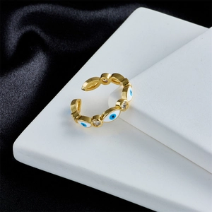 Close-up of golden adjustable evil eye ring with blue enamel and white zircon details