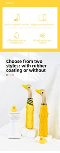 Close-up of creative wooden duck head handle on a yellow sun and rain umbrella