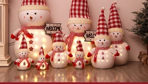 Close-up of glowing LED Christmas snowman dolls with plaid hats and welcome stars