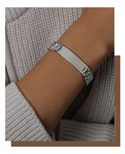 Polished silver watch-band chain bracelet on a model wearing a grey knitted sweater