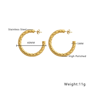 Detail of 40mm golden hollow hoop earrings with textured diamond-pattern finish