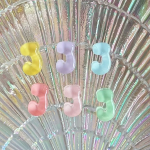 Mini transparent J-shaped resin charms in pastel yellow, purple, blue, and pink colors