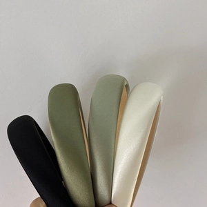 Satin padded headbands in black, white, and shades of green shown as a group