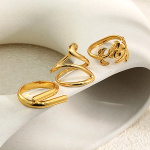 Three-piece 18K gold plated ring set featuring floral, spiral and cross designs