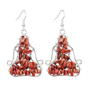 Detailed macro view of handmade wire-wrapped red stone earrings with bohemian yoga-style design