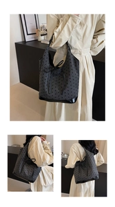 Detail view of gray canvas tote bag with black bow patterns and leather trim shown on a model