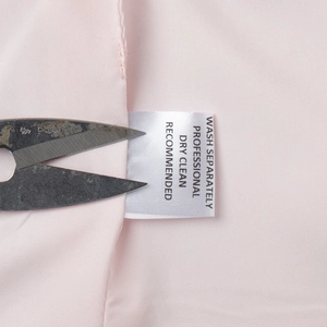 Vue détaillée de l'étiquette de lavage et du tissu rose sur cet ensemble jupe élégant