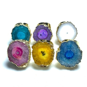 Detalle de seis anillos coloridos de ágata druzy con bordes chapados en oro irregular