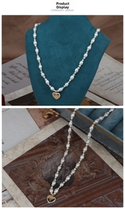 Detail of freshwater pearl necklace with a gold heart pendant and crown relief design