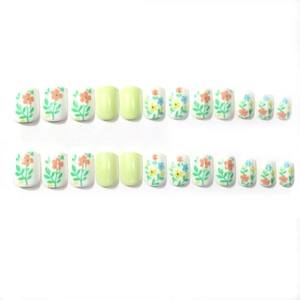 Close-up of 24pcs short square press-on nails with light green and floral pattern
