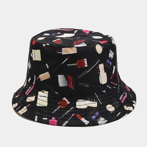Détail d'un chapeau bob noir avec des imprimés cosmétiques comme du rouge à lèvres et parfum