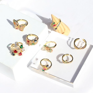 Macro shot of gold-plated rings with colorful zircon in butterfly and snake designs